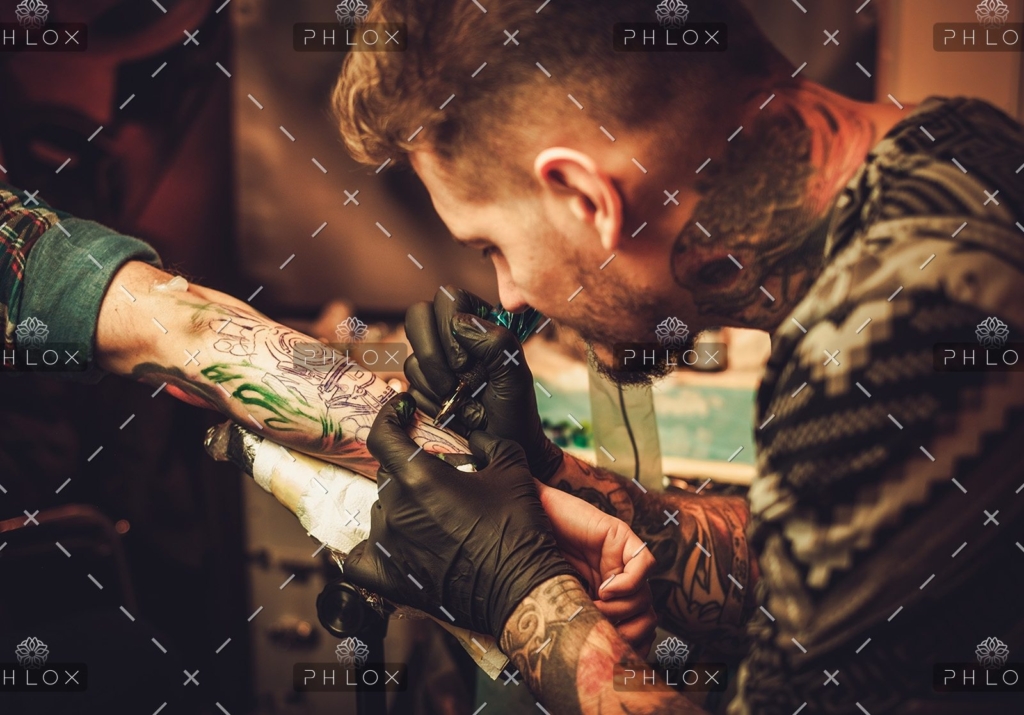 demo-attachment-354-tattoo-artist-makes-a-tattoo-on-a-mans-hand-PECZRE2-1